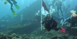 KARANGASEM, BALINEWS.ID - Ombak besar memecah di bibir pantai, namun tak sedikit pun menyurutkan semangat para penyelam. Di dasar laut Tulamben yang tenang, pu…