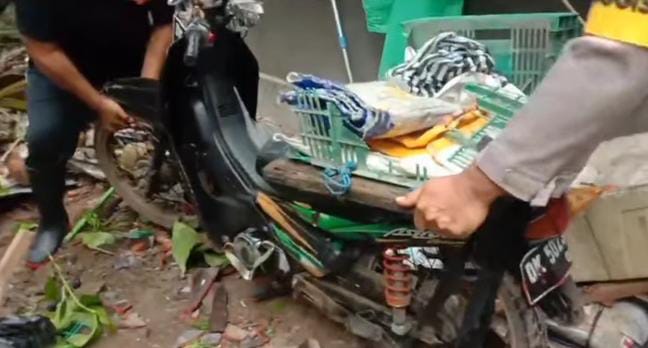 Petugas berupaya mengekuasi barang yang tertimpa pohon di rumah korban.