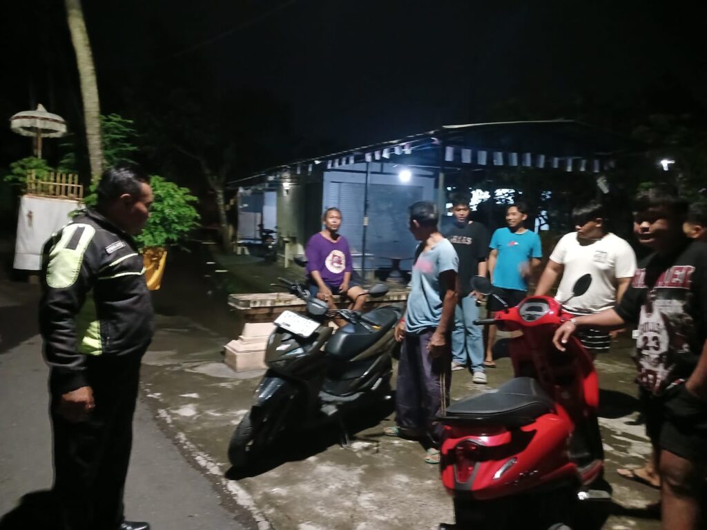 Suasana masyarakat yang menyaksikan dan menolong korban jatuh di Jalan Raya Saba, Blahbatuh.