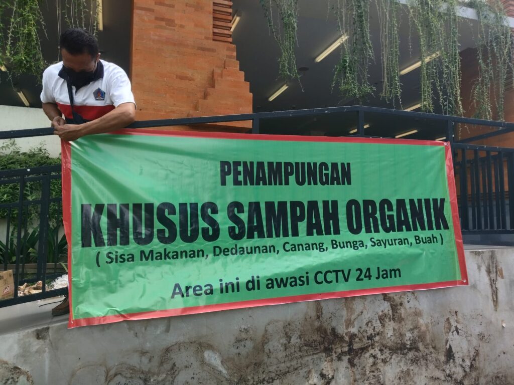 Petugas memasang baliho pengumuman sampah organik di Pasar Umum Galiran.