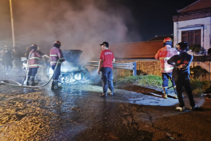 Mobil sedan Timor berwarna hijau terbakar di Jalan Bypass Ngurah Rai, Sesetan, Denpasar Selatan.