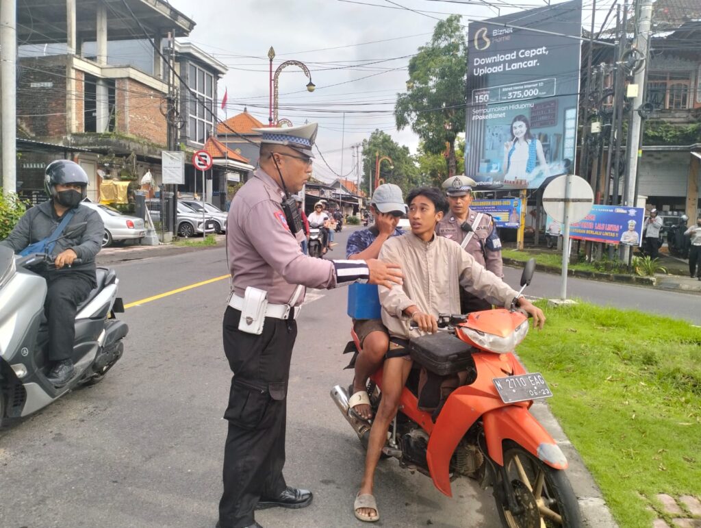 Remaja yang berkendara tanpa helm ini diberhentikan oleh polisi. Ia diberikan penataran singkat mengenai tertib berlalu lintas.