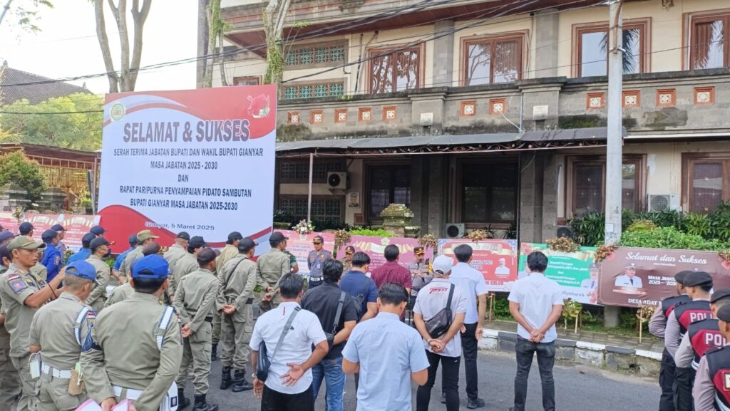 Aparat berjaga di gedung DPRD Gianyar yang dihiasi puluhan karangan bunga ucapan selamat.