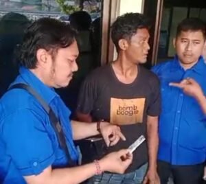 Sopir truk Iswanto (tengah) diapit petugas yang menunjukkan hasil urine positif narkoba di Pelabuhan Padangbai.