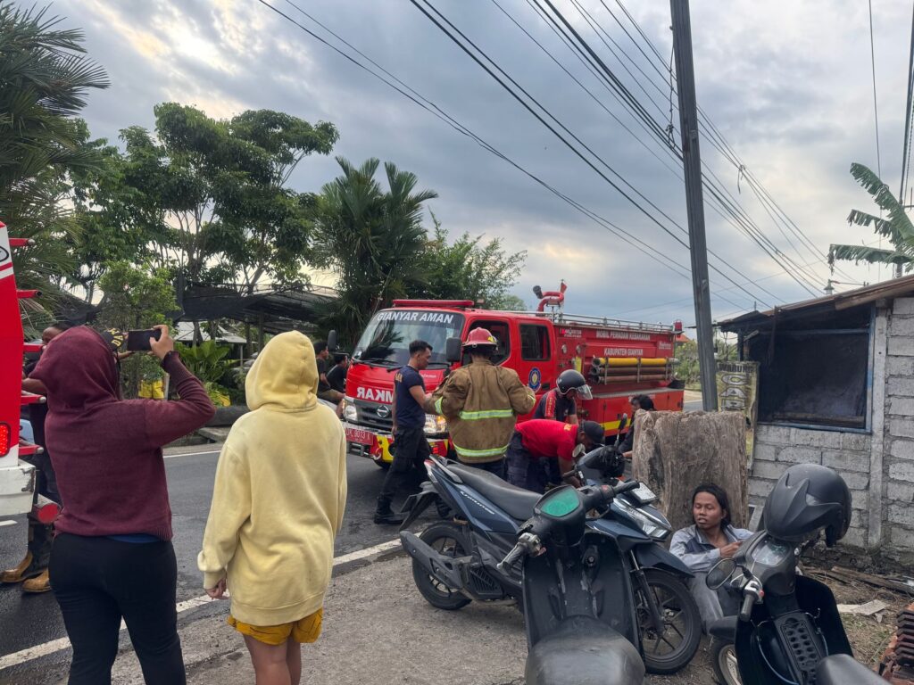 Petugas menangani kebakaran yang menimpa gudang kayu di Desa Saba.