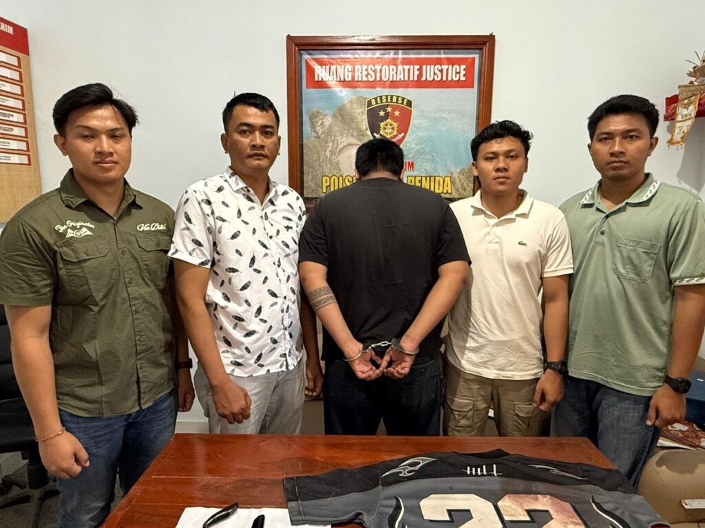 Pelaku penuukan Muhamad Iqbal dengan kedua tangan diborgol oleh petugas kepolisian Nusa Penida.