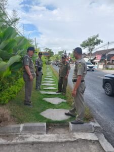 Petugas Satpol PP Gianyar mengecek trotoar yang beralih fungsi menjadi taman.