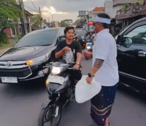 Anggota PBB PC Gianyar membagi nasi gratis kepada masyarakat yang melintasi jalur Bedulu, Blahbatuh.