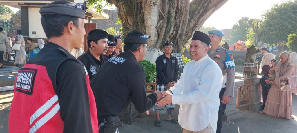 Pecalang Gianyar (kiri) bersalaman dengan Kapolres Gianyar usai sholat Iduladha di Alun-alun Gianyar.