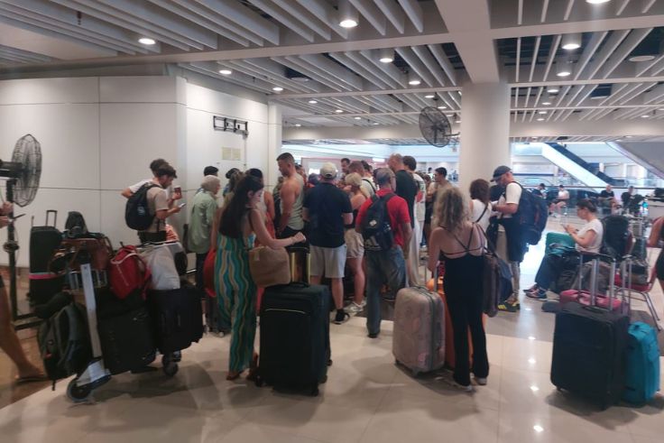 Penumpang Qatar Airways antre di Terminal Internasional Bandara Ngurah Rai setelah penerbangan QR963 rute Denpasar–Doha dibatalkan akibat dampak ketegangan geopolitik Iran–Israel.