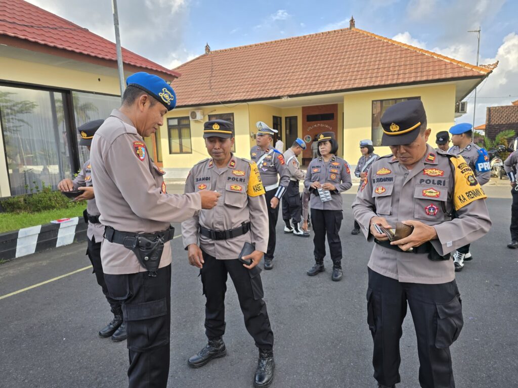 Anggota Propam Polres Karangasem (kiri) memeriksa kelengkapan anggotanya sebelum menggelar Operasi Patuh Agung 2025.