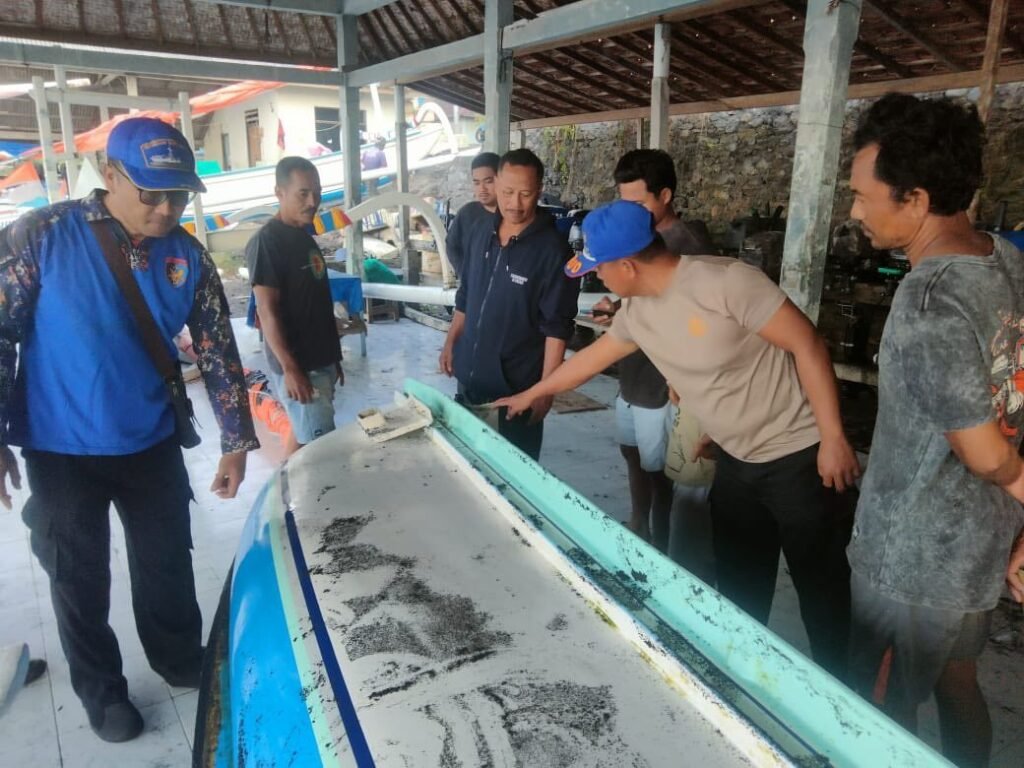 Petugas melihat kerusakan perahu yang melanda nelayan Karangasem.