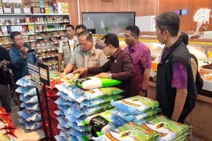 Petugas Satgas Pangan Polda Bali memeriksa kualitas beras saat sidak di sejumlah titik di Denpasar, Selasa (22/7),
