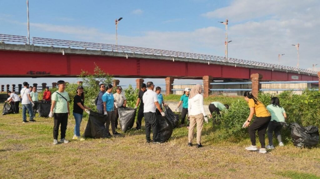 Pegawai PLN Bali Timur membersihkan sampah plastik di bawah jembatan merah Tukad Unda, Klungkung.