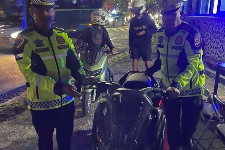 Petugas Sat Lantas Polresta Denpasar menindak pengendara pelanggar lalu lintas saat razia di Simpang Direktorat, Kuta, Minggu (10/8/2025) dini hari.