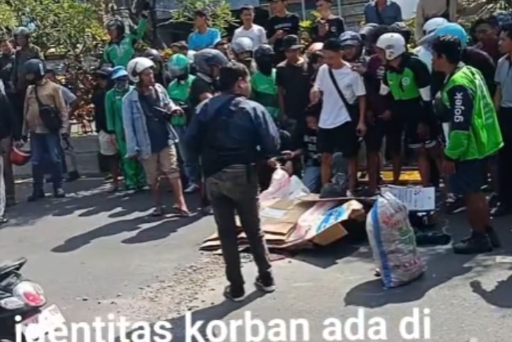 Warga turut mengevakuasi jasad korban kecelakaan maut di Jalan Imam Bonjol, Denpasar Barat.