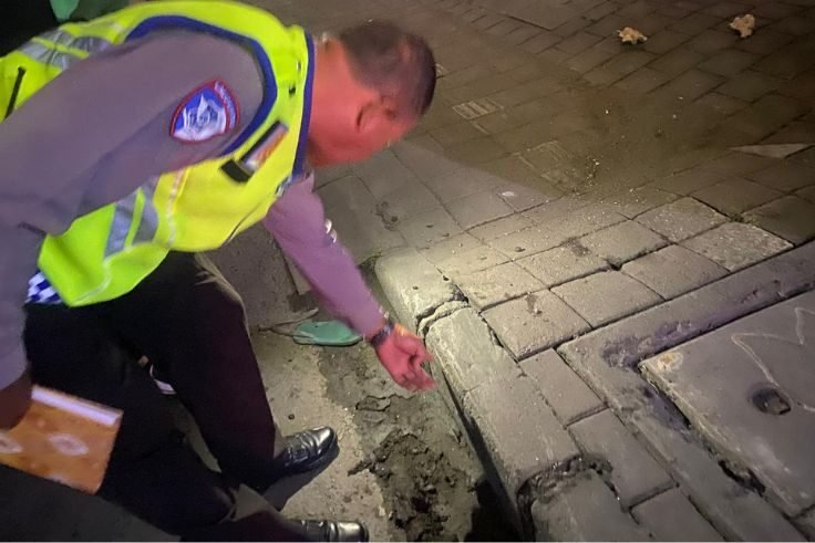 etugas kepolisian melakukan olah TKP kecelakaan maut yang menewaskan AEP di Jalan Gunung Soputan.