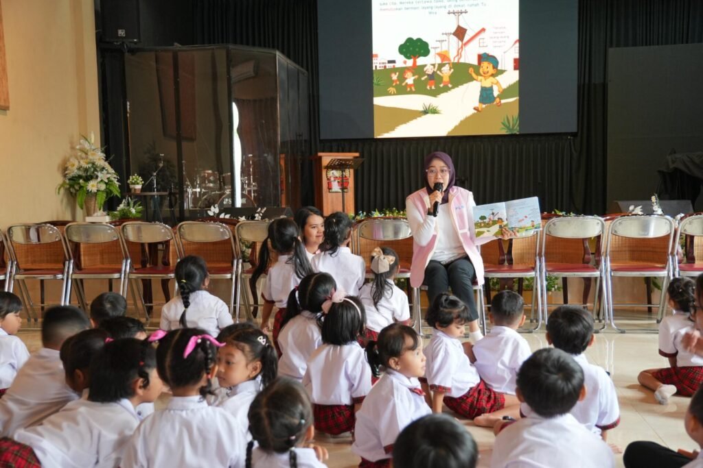 Manager PLN UP3 Bali Timur, Imadya Nareswari (duduk di kursi) mendongeng cerita berjudul “Gung Ngurah Berudeng Biru dan Layangan Nakal” di depan siswa-siswi TK Tunas Kasih Klungkung.