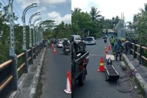 Petugas tengah memasang railing pengaman di Jembatan Cau Belayu, Tabanan,