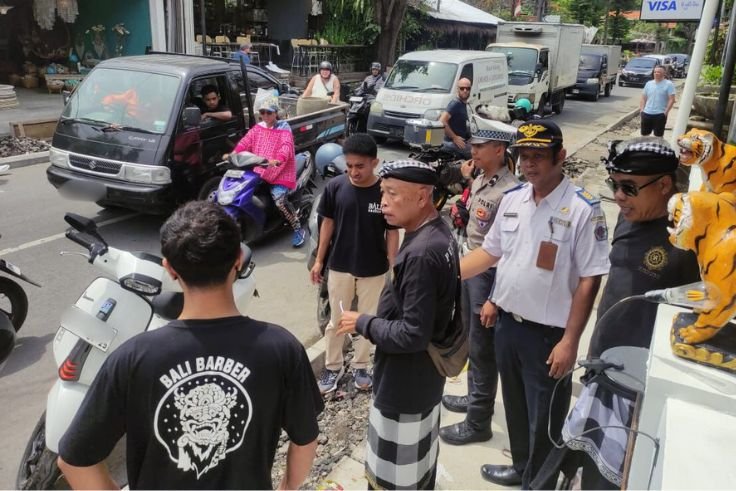 Petugas gabungan menertibkan kendaraan yang parkir liar di sepanjang Jalan Danau Tamblingan, Sanur, Denpasar Selatan, Senin (27/10/2025).