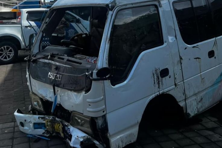 kondisi mobil travel yang ringsek usai menabrak tiang lampu dan terguling.