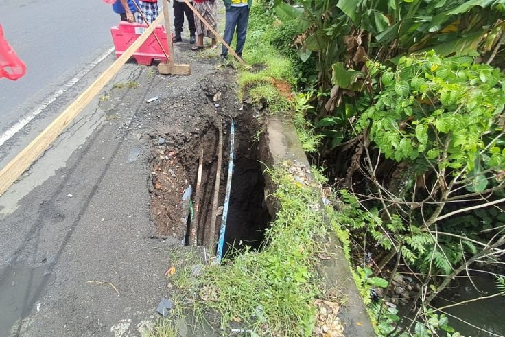 Kondisi pinggir Jalan Nasional Denpasar–Gilimanuk di Banjar Meliling Kawan, Kerambitan, Tabanan, yang jebol akibat hujan deras.