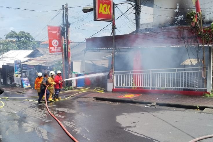 Petugas pemadam kebakaran berupaya memadamkan api yang melalap outlet ACK di kawasan Bualu, Kuta Selatan, Badung, Selasa (20/1/2026).