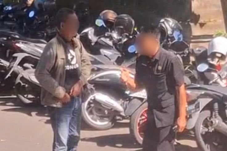Tangkapan layar video memperlihatkan seorang wartawan saat berupaya meliput rapat penanganan sampah di Jayasabha namun aksesnya dibatasi oleh petugas keamanan.
