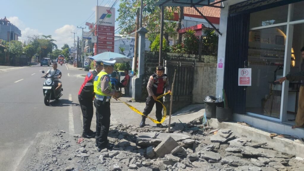 Polisi memeriksa trotoar yang rusak akibat ledakan di depan SPBU Desa Darmasaba, Abiansemal, Badung.