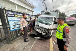 Petugas kepolisian melakukan penanganan di lokasi kecelakaan antara Suzuki Mega Carry dan truk Isuzu di Jalan Mahendradatta, Denpasar, Senin (18/5/2026).