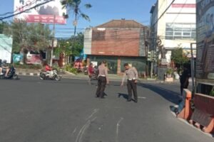 Petugas Satlantas Polresta Denpasar melakukan olah TKP kecelakaan maut yang menewaskan seorang pengendara motor di Simpang Buagan, Denpasar Barat, Rabu (24/6/2026).