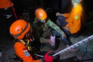 Tim SAR gabungan mengevakuasi Roger (55) yang terjebak di tebing Pantai Pandawa.
