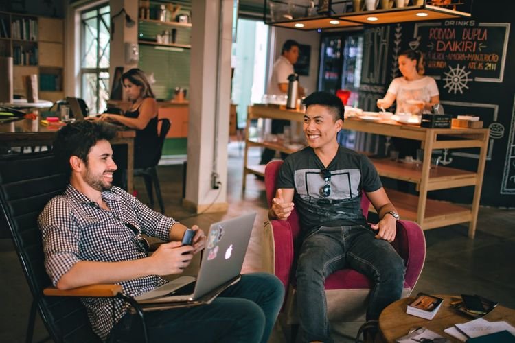 Anak muda bekerja dan berdiskusi di coworking space Bali sebagai ilustrasi membangun penghasilan tambahan di Bali melalui freelance, bisnis digital, dan pekerjaan remote.