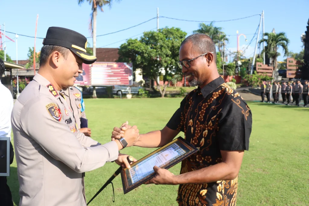 Nyoman Ariawan (kanan) saat menerima penghargaan dari Kapolres Gianyar atas dedikasi membantu perbaikan kendaraan dinas Polsek Blahbatuh.