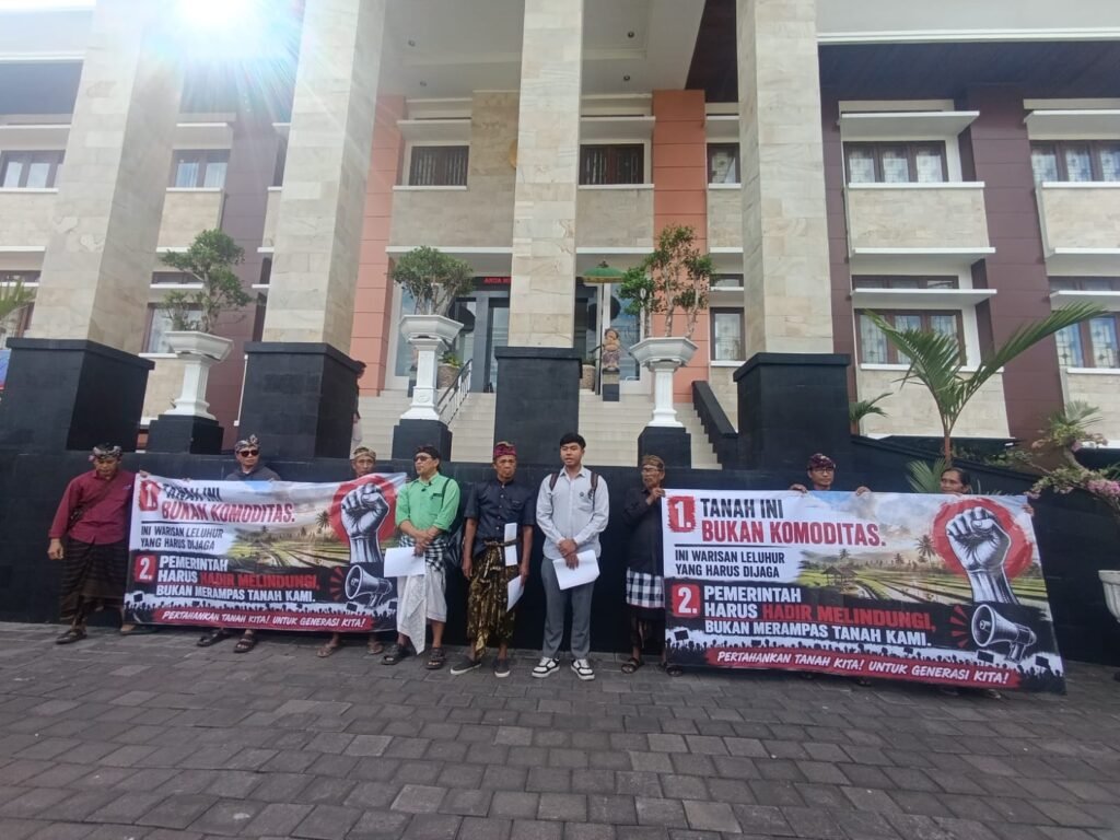 Petani membentangkan spanduk menolak tanah warisan dijual untuk GOR Gianyar.