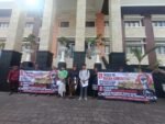 Petani membentangkan spanduk menolak tanah warisan dijual untuk GOR Gianyar.