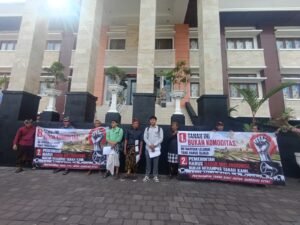 Petani membentangkan spanduk menolak tanah warisan dijual untuk GOR Gianyar.