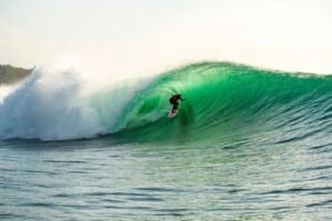 A surfer rides a powerful barrel at Bali's iconic Padang Padang Beach.