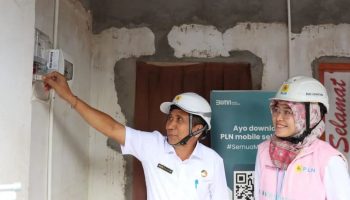 Pj Sekda Bali (kiri) saat mencoba menyalakan listrik di rumah Winarta.