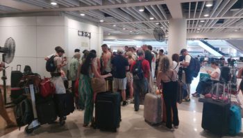 Penumpang Qatar Airways antre di Terminal Internasional Bandara Ngurah Rai setelah penerbangan QR963 rute Denpasar–Doha dibatalkan akibat dampak ketegangan geopolitik Iran–Israel.